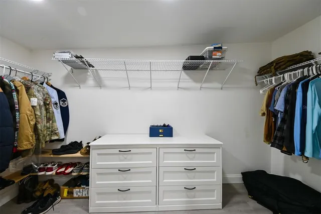 a view of walk in closet with clothes and shoes