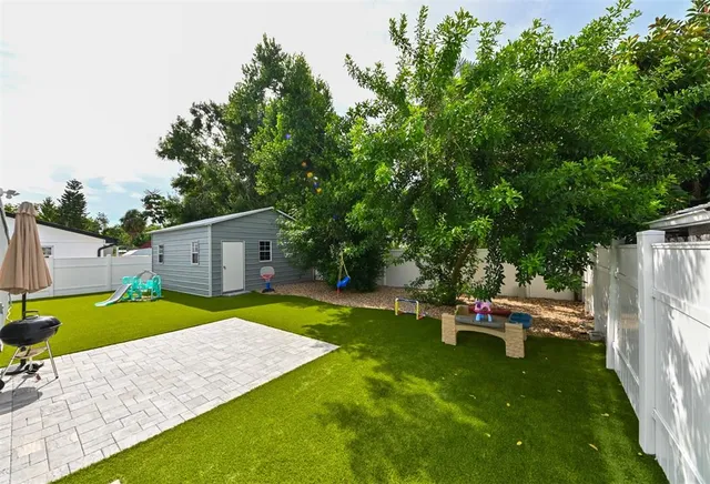 a view of a backyard with a table and chairs under an umbrella