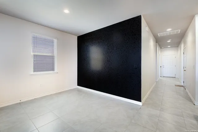 a view of an empty room with a ceiling fan and window