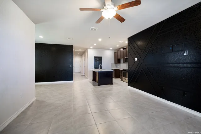 a kitchen with kitchen island a counter top space appliances and a ceiling fan