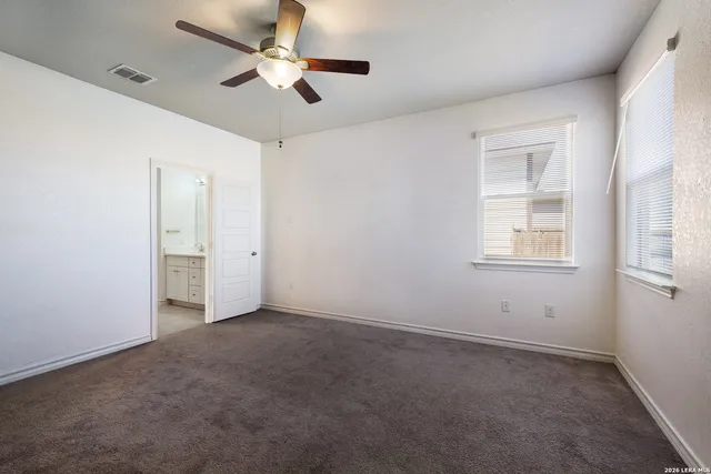 an empty room with closet and a chandelier fan