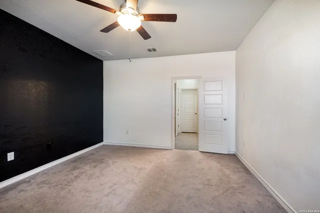 an empty room with a window and a fan