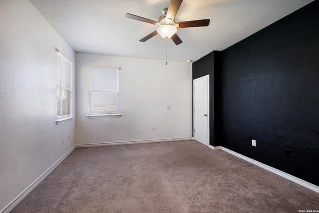 an empty room with windows and fan