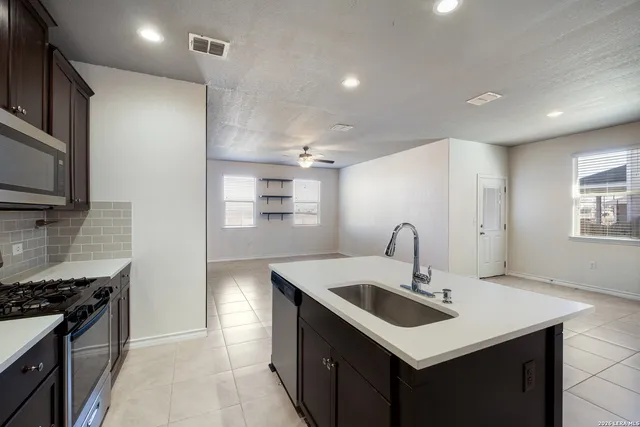 a kitchen that has a sink a stove and a microwave