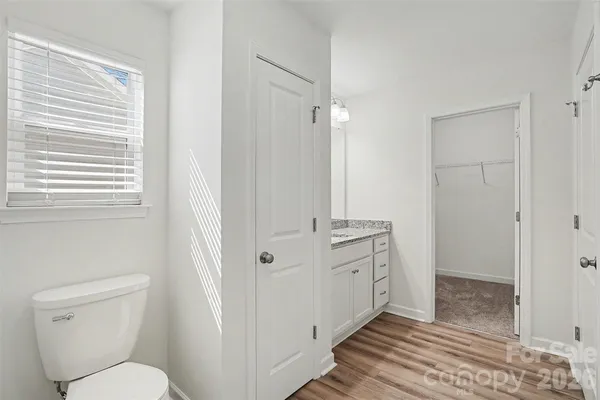 a bathroom with a granite countertop toilet a sink and a mirror