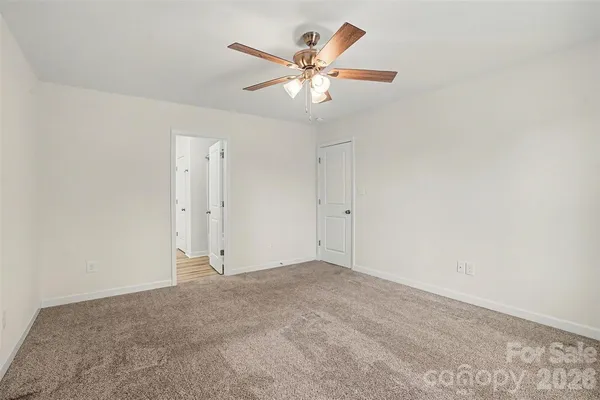 an empty room with closet and ceiling fan