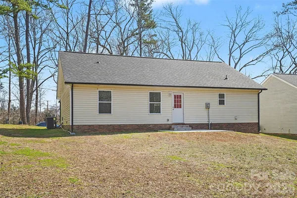 a view of house with backyard and trees