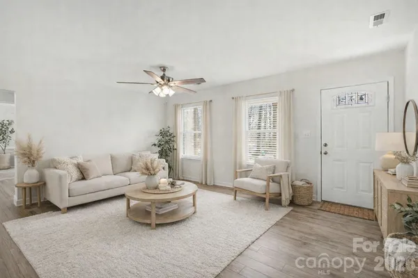 a living room with furniture and a large mirror with wooden floor