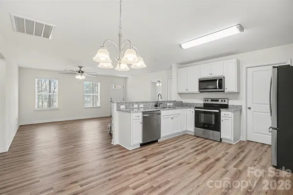 a kitchen with a sink stainless steel appliances and window