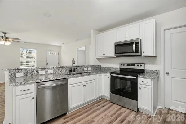 a kitchen with appliances a sink and cabinets