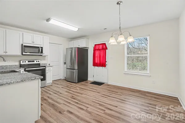 a very nice looking kitchen with stainless steel appliances granite countertop a stove a sink dishwasher and a microwave