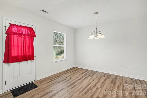 a view of a room with wooden floor closet and a window