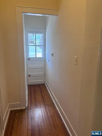 a view of a room with wooden floor and window