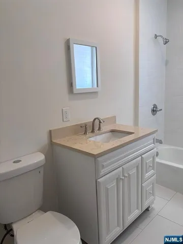 a bathroom with a granite countertop toilet a sink and a bathtub