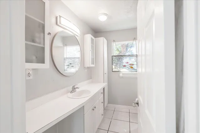 a bathroom with a granite countertop sink a mirror and a shower