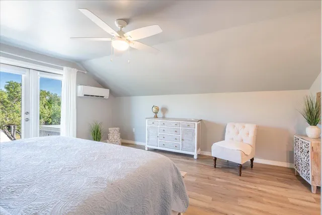 a bedroom with a bed a chair and a large window