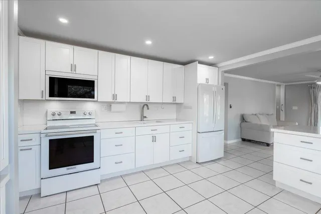 a kitchen with white cabinets appliances and sink