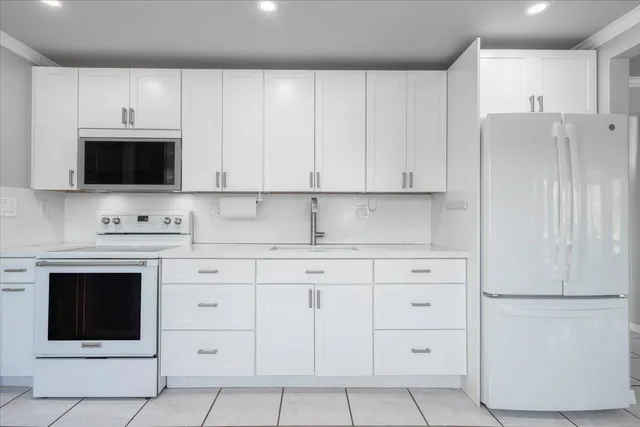 a kitchen with granite countertop white cabinets and stainless steel appliances