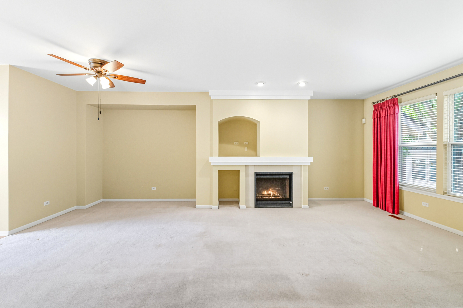 5662 Cambridge Way Hanover Park, IL 60133 - Photo 9 of 34 an empty room with windows fireplace and a small kitchen