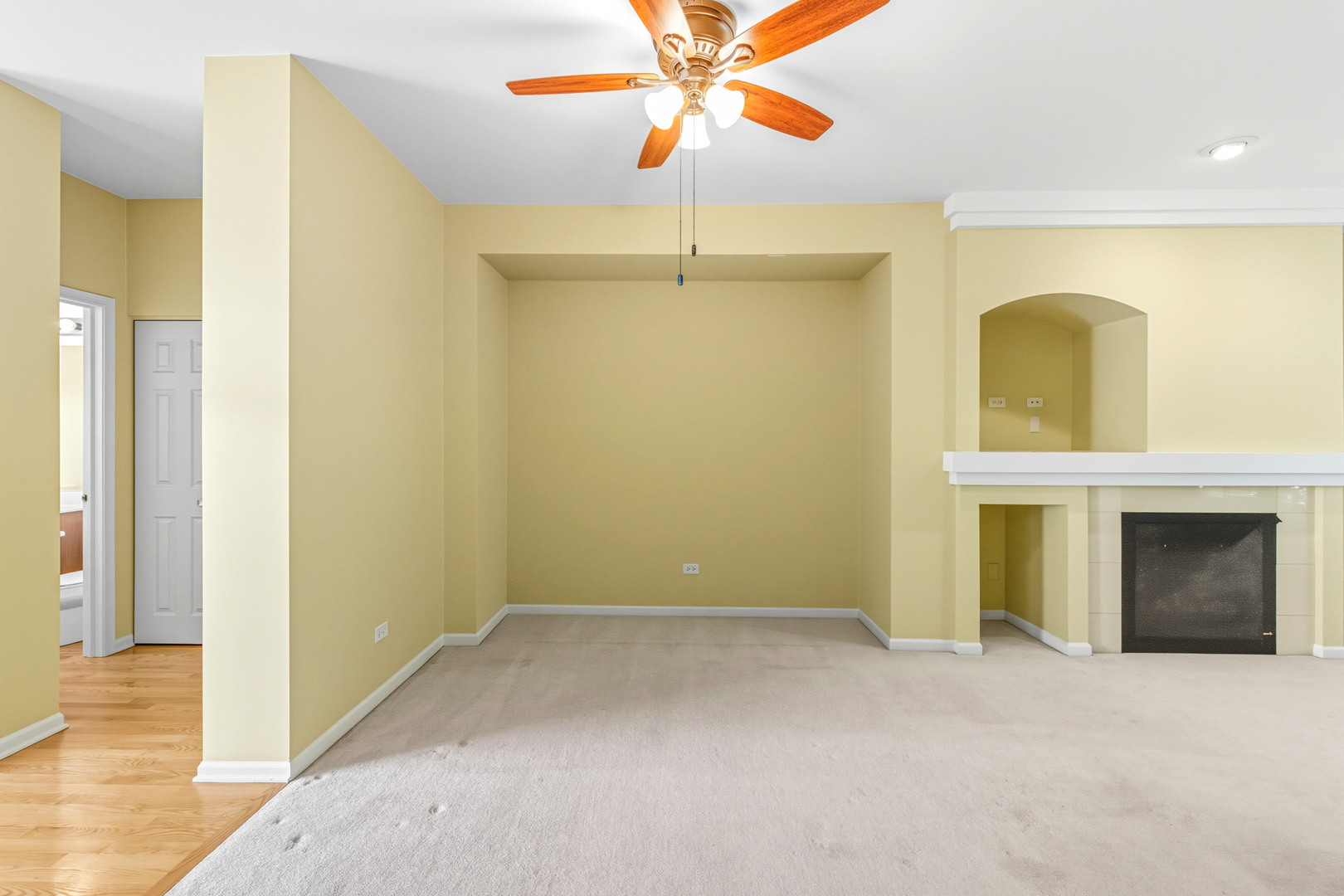 5662 Cambridge Way Hanover Park, IL 60133 - Photo 10 of 34 a view of a room with a fireplace a ceiling fan and wooden floor