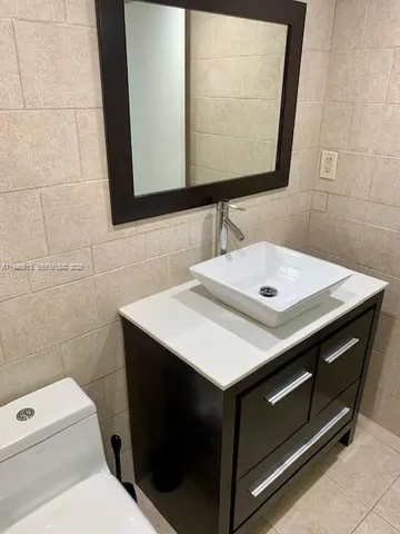a bathroom with a sink toilet and mirror