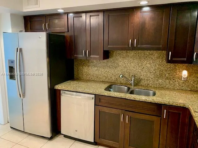 a kitchen with stainless steel appliances granite countertop a refrigerator and a sink