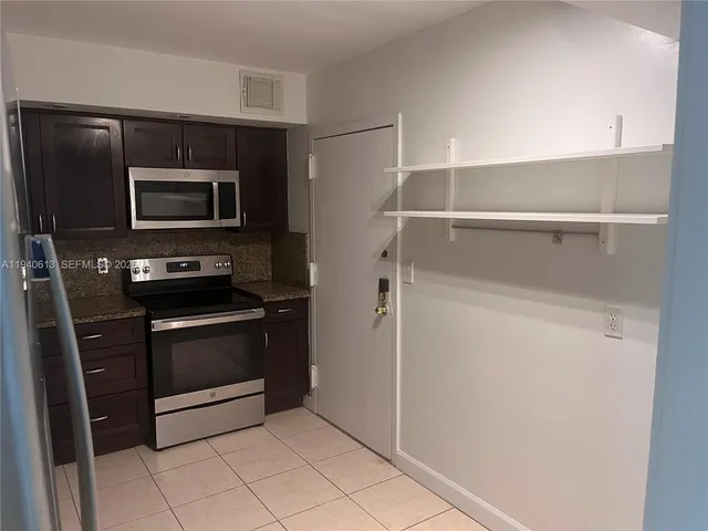 a kitchen with granite countertop cabinets and steel stainless steel appliances
