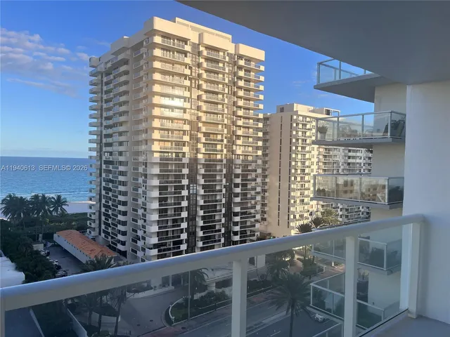 a view of a balcony with a couple of cars parked in parking lot
