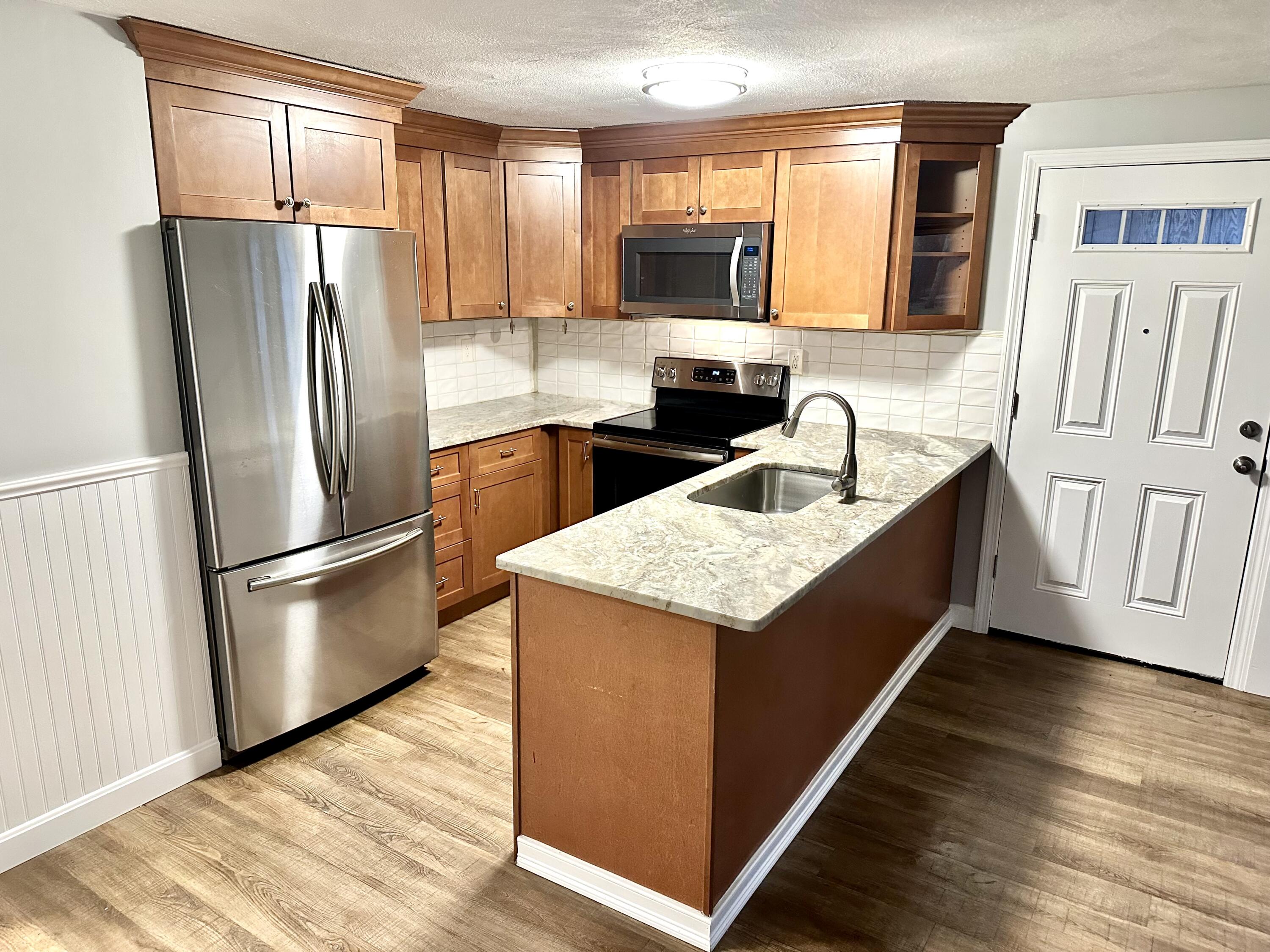 35 Ashumet Road, Unit 10B Mashpee, MA 02649 - Photo 2 of 7 a kitchen with stainless steel appliances granite countertop a refrigerator a stove a sink and a microwave