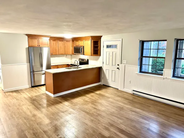 a view of a kitchen with wooden floor and electronic appliances