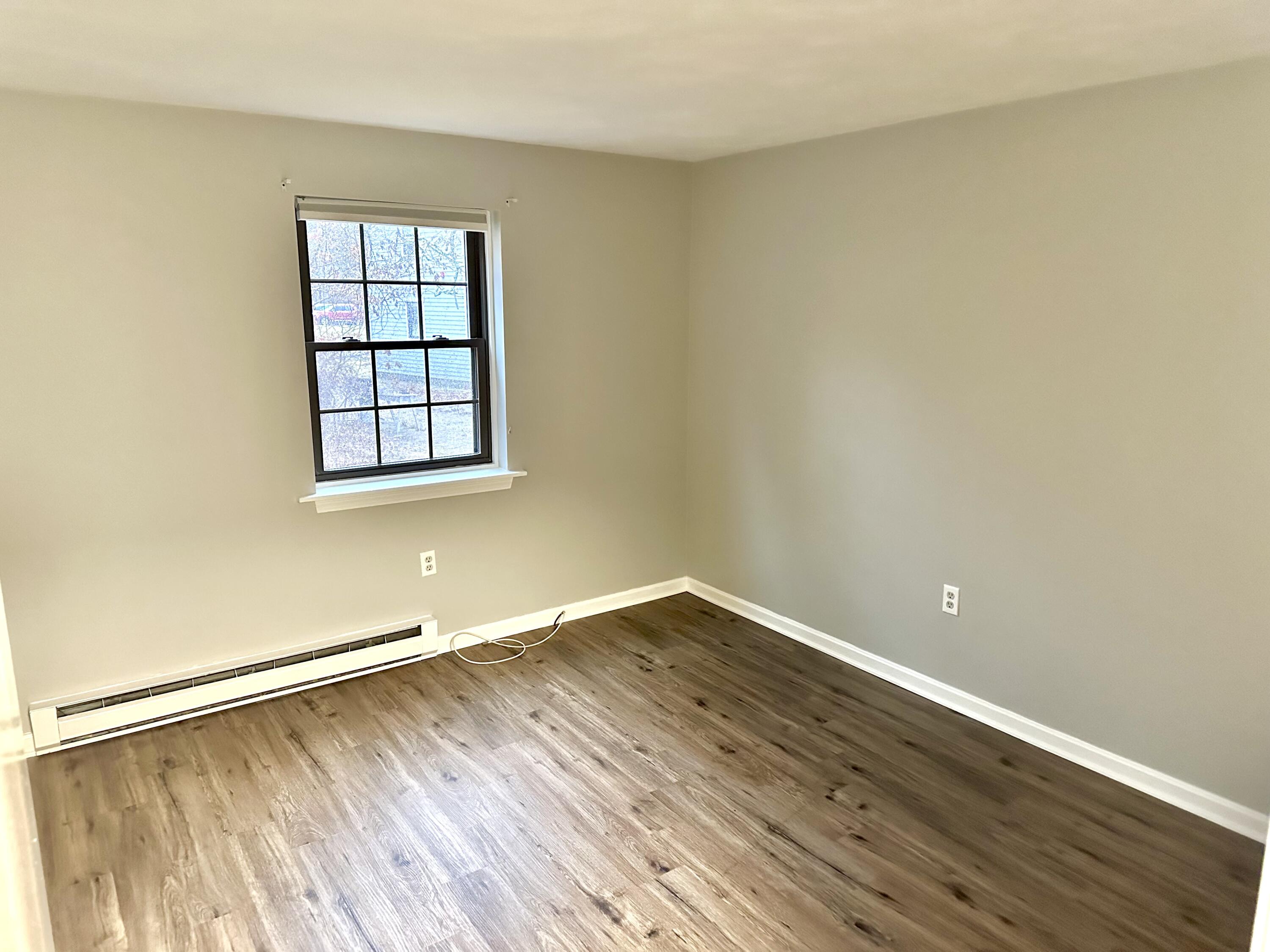 35 Ashumet Road, Unit 10B Mashpee, MA 02649 - Photo 7 of 7 an empty room with wooden floor and windows