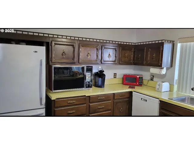 a kitchen with granite countertop a refrigerator and a sink