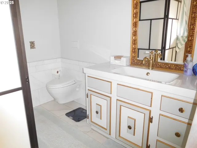 a bathroom with a sink a toilet and a mirror