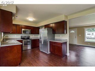 13240 Southeast Rusk Road Milwaukie, OR 97222 - Photo 5 of 24 a kitchen with stainless steel appliances granite countertop a stove a sink dishwasher a refrigerator and a microwave oven with wooden floor