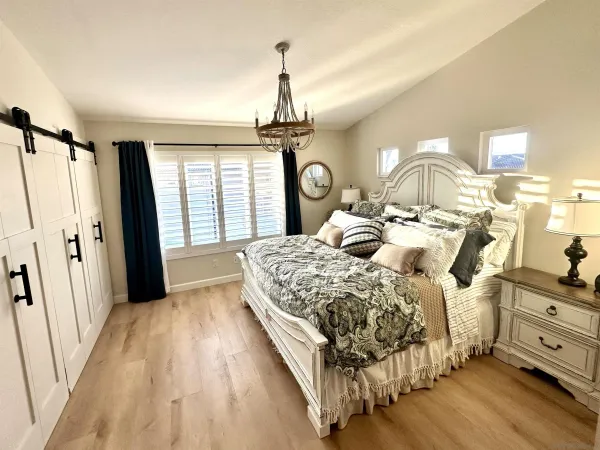 a bedroom with a bed and a chandelier