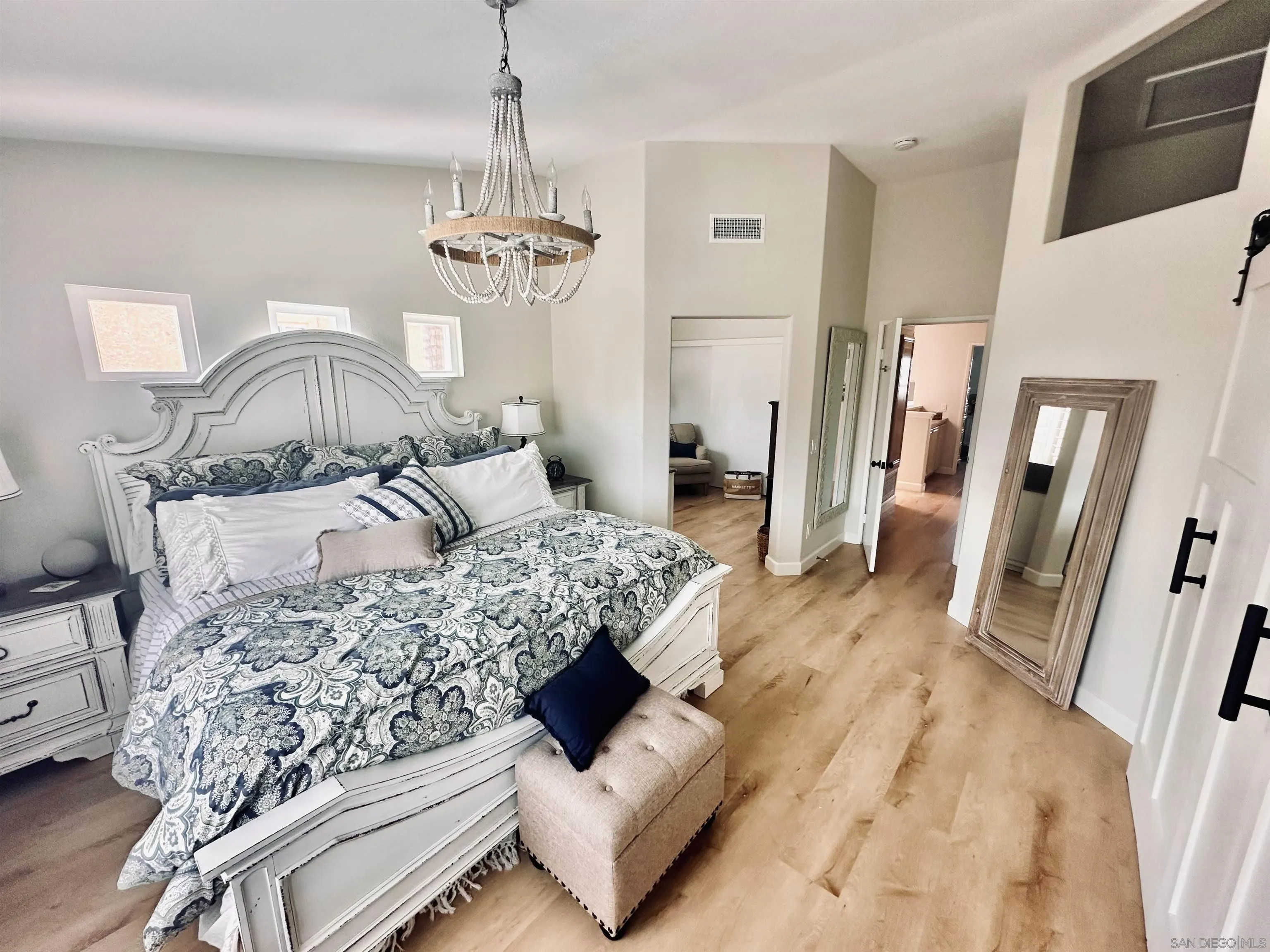 1259 Natoma Way, Unit C Oceanside, CA 92057 - Photo 30 of 52 a bedroom with a bed and a chandelier