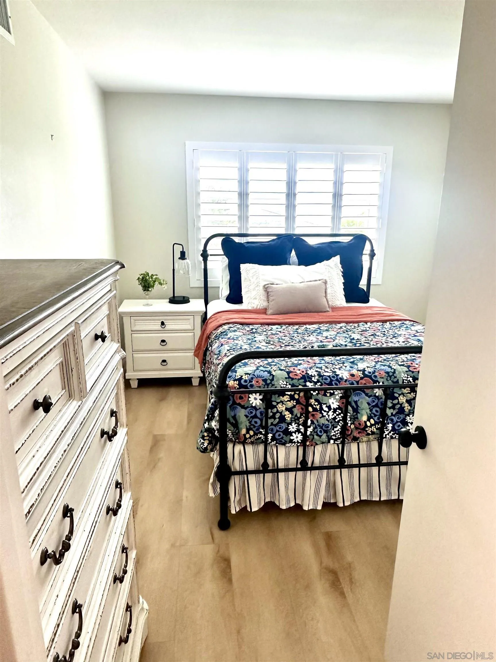 1259 Natoma Way, Unit C Oceanside, CA 92057 - Photo 36 of 52 a large bed sitting in a bedroom next to a window with lamp