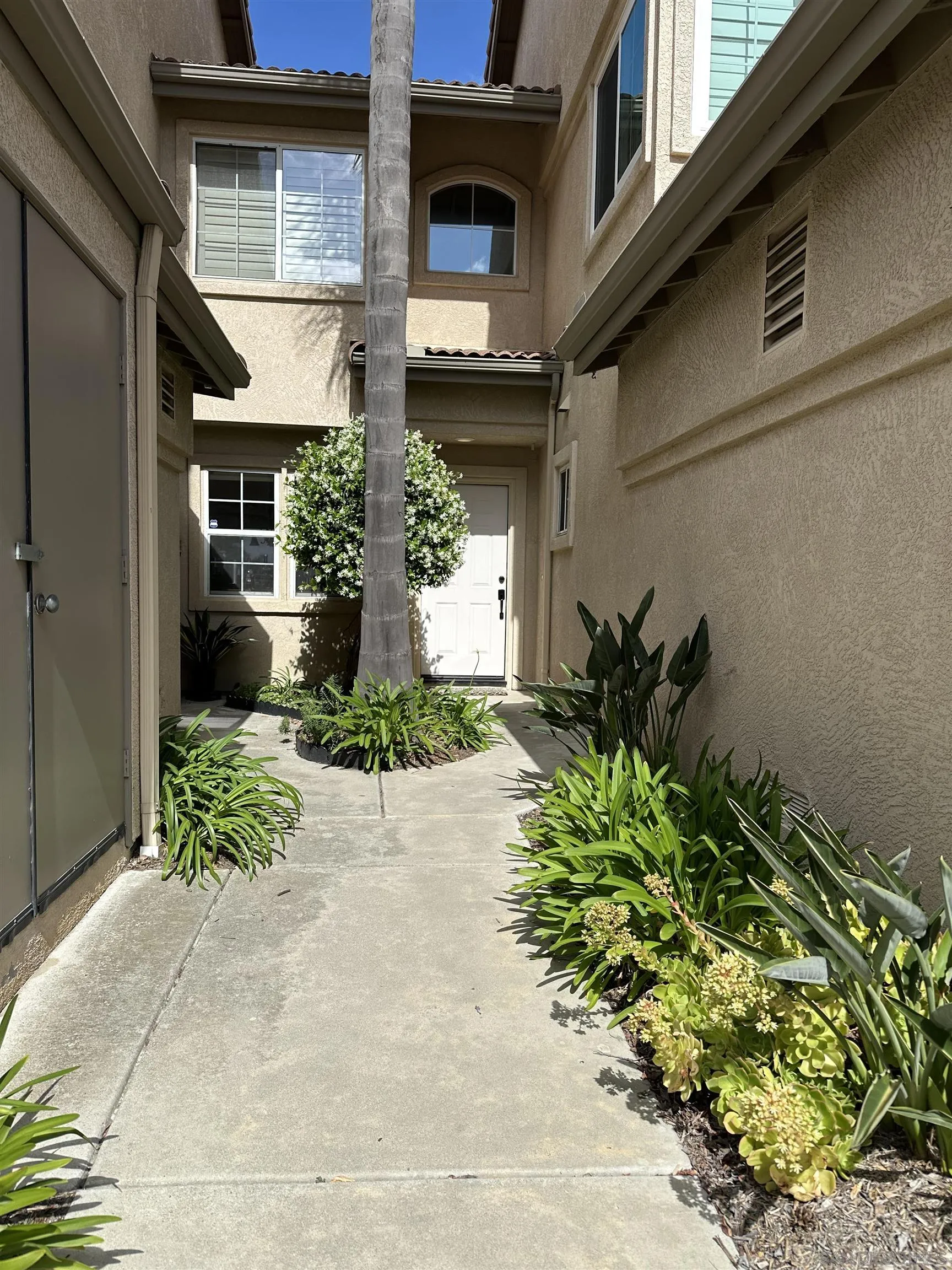 1259 Natoma Way, Unit C Oceanside, CA 92057 - Photo 38 of 52 a front view of a house with garden