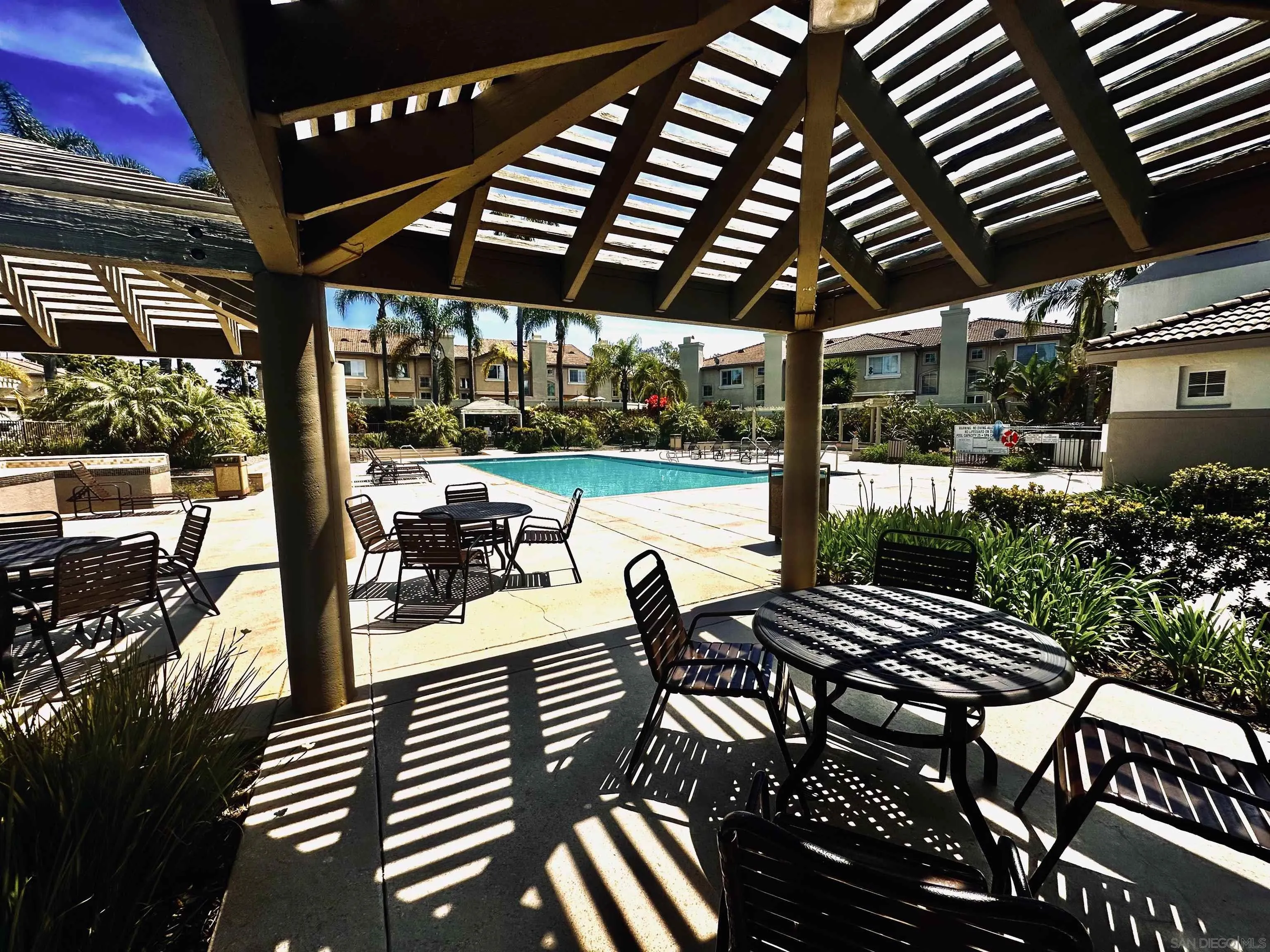 1259 Natoma Way, Unit C Oceanside, CA 92057 - Photo 43 of 52 a view of a patio with table and chairs potted plants and floor to ceiling window