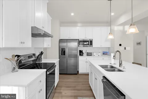 a kitchen with a stove and white cabinets
