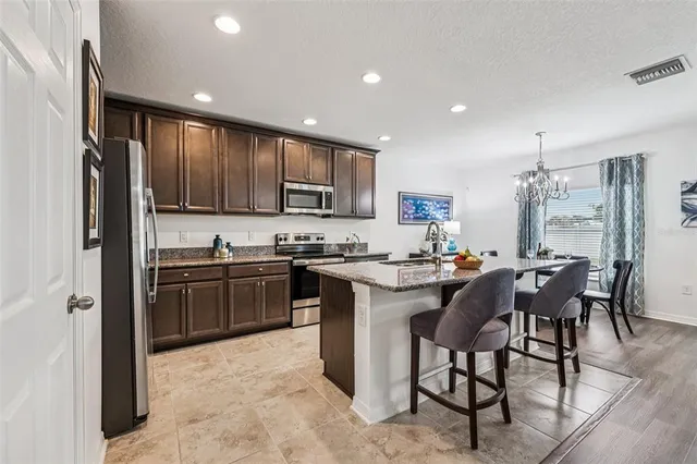 a kitchen with kitchen island granite countertop wooden cabinets and stainless steel appliances