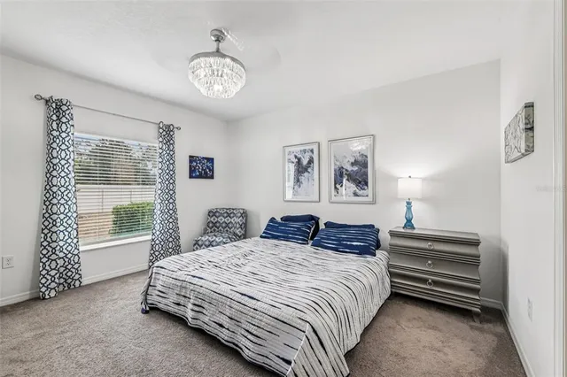 a bedroom with a bed a lamp and a large window