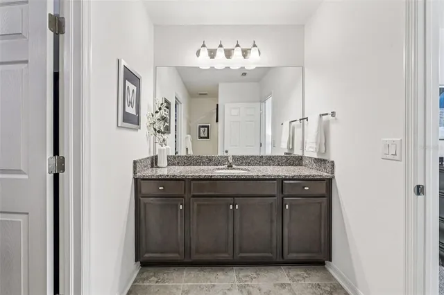 a bathroom with a granite countertop sink a mirror and a shower