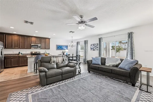 a living room with furniture kitchen and a wooden floor