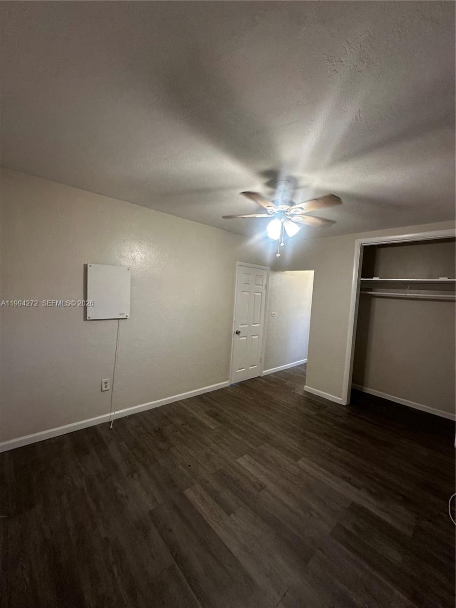 112 Northeast 63rd Street, Unit 112 Miami, FL 33138 - Photo 13 of 18 a view of an empty room with wooden floor and a ceiling fan