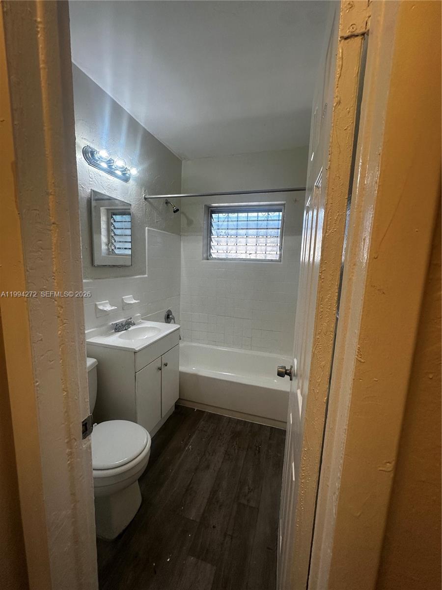 112 Northeast 63rd Street, Unit 112 Miami, FL 33138 - Photo 16 of 18 a bathroom with a granite countertop toilet a sink and a bathtub