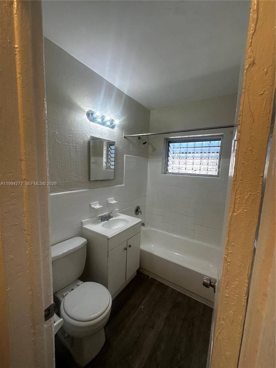 112 Northeast 63rd Street, Unit 112 Miami, FL 33138 - Photo 17 of 18 a bathroom with a toilet sink and mirror