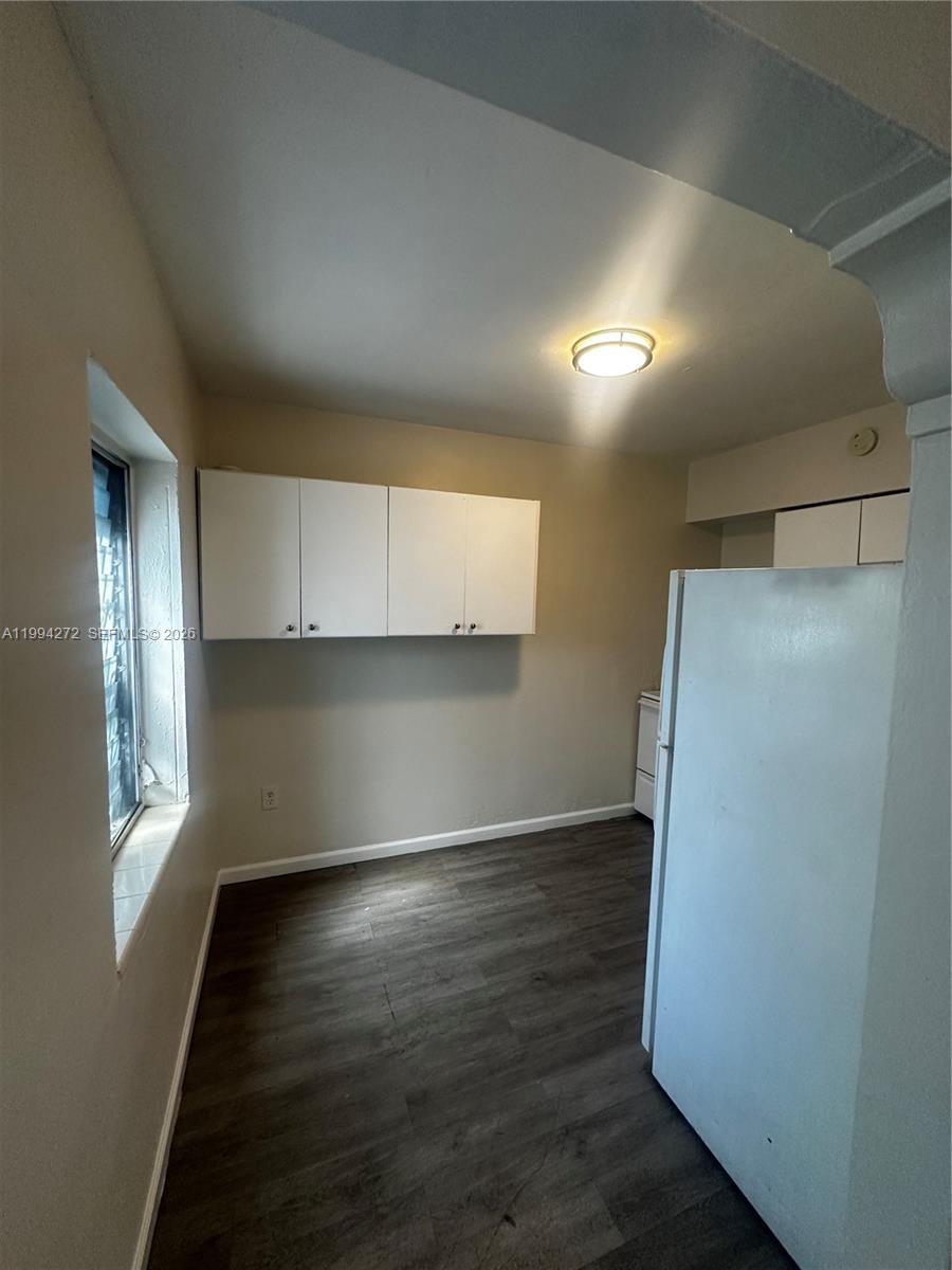112 Northeast 63rd Street, Unit 112 Miami, FL 33138 - Photo 5 of 18 a view of an empty room with wooden floor and a window