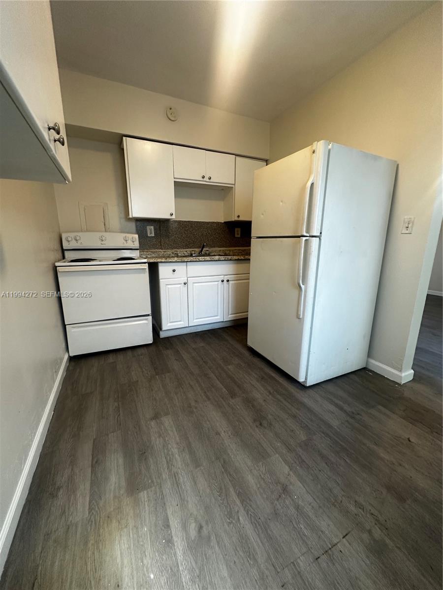 112 Northeast 63rd Street, Unit 112 Miami, FL 33138 - Photo 7 of 18 a kitchen with granite countertop a refrigerator and a stove top oven