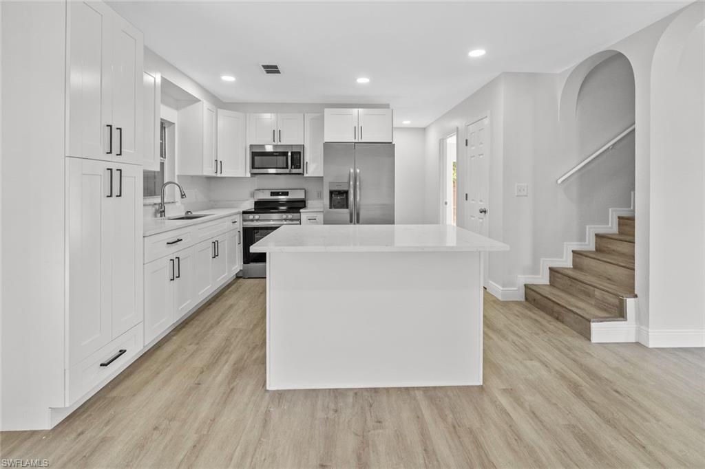 Undisclosed Address Naples, FL 34113 - Photo 18 of 21 a large kitchen with stainless steel appliances refrigerator a stove top oven with wooden floors